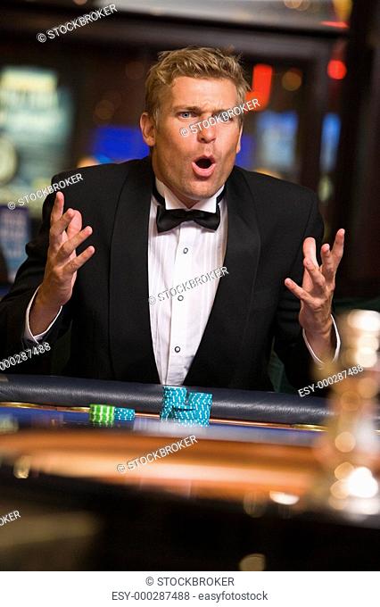 Man in casino playing roulette and losing selective focus