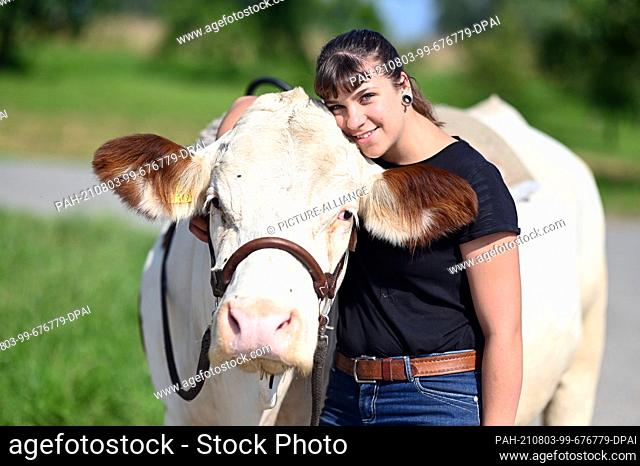 23 July 2021, Baden-Wuerttemberg, Ölbronn-Dürrn: Sonja Keller, taken with the cow Melina, with whom she rides out. (to dpa ""22-year-old regularly rides a cow...