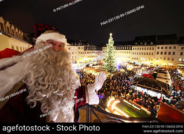 30 November 2023, Thuringia, Gera: A Santa Claus figure stands on the balcony of the town hall and waves to visitors at the opening of the Christmas market