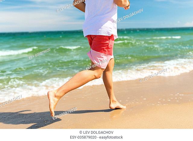 fitness, sport, people and healthy lifestyle concept - happy young man running along summer beach