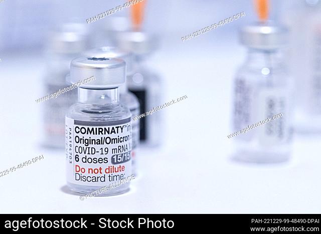 29 December 2022, Lower Saxony, Hanover: An empty ampoule (l) of the BA.4/BA.5 vaccine from BioNTech/Pfizer against the Corona virus (SARS-CoV-2) stands in the...