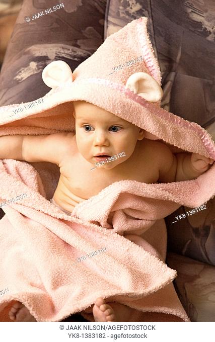 Emotional Eight Month Old Infant Girl Sitting in Bathrobe