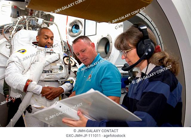 Astronaut Robert Satcher, STS-129 mission specialist, participates in an Extravehicular Mobility Unit (EMU) spacesuit fit check in the Space Station Airlock...