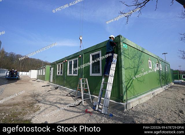 25 March 2022, Hamburg: Workers set up housing containers for Ukrainian refugees on Schnackenburgallee. The accommodation with canteen and school classroom...