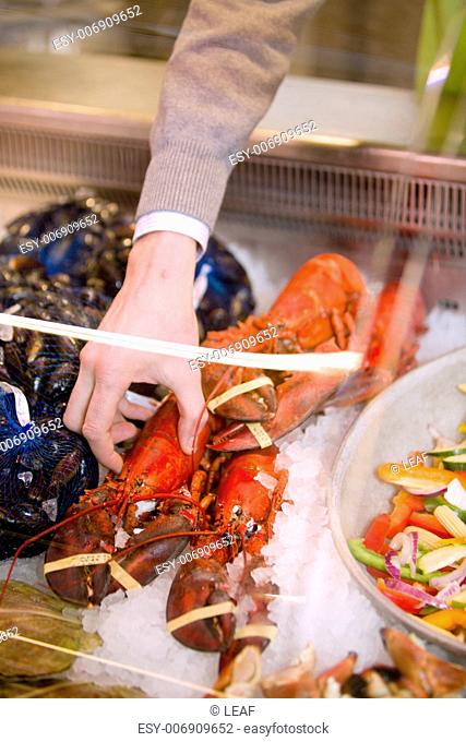 A freshly cooked lobster in a grocery store seafood display
