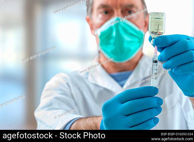 The doctor fills a syringe with vaccine