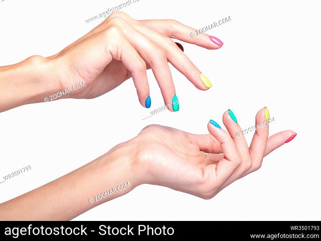 Female fingers with fancy bright green, yellow, pink and blue nails manicure. Girl's hands isolated on white background