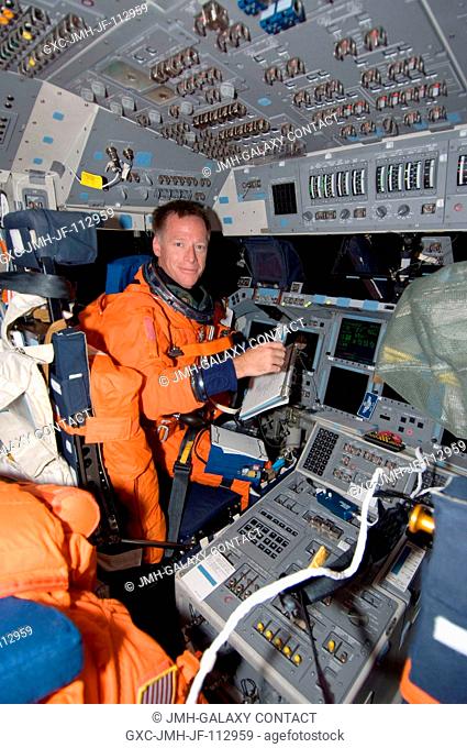 Astronaut Chris Ferguson, STS-126 commander, attired in his shuttle launch and entry suit, takes a moment for a photo while occupying the commander's station on...