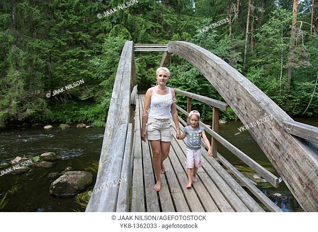 Mother With Kid Walking Over Wooden Bridge Holding Hands, Põlva County, Estonia, Europe