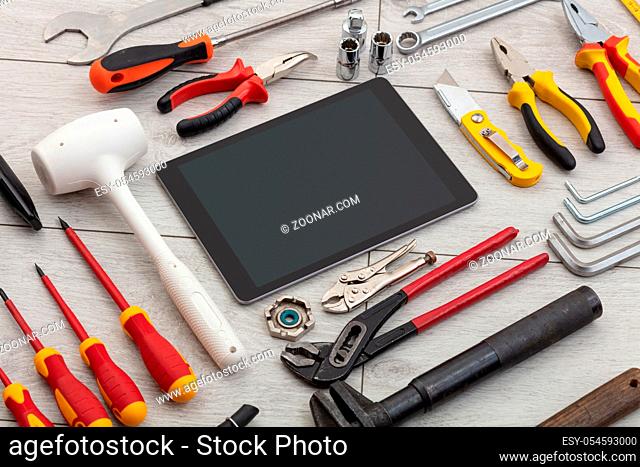 Tablet with empty screen and construction tools around
