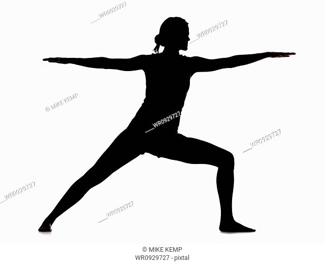 Silhouette of young woman exercising, digital composite