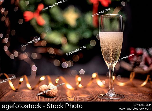 Smooth shady christmas and new year decoration background with round bokeh, golden ribbon and glass of champagne and cork