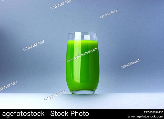 Glass of green juice isolated on white background with copy space for text, fresh apple and celery cocktail, healthy drink concept