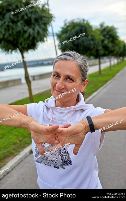 Smiling mature woman stretching fingers