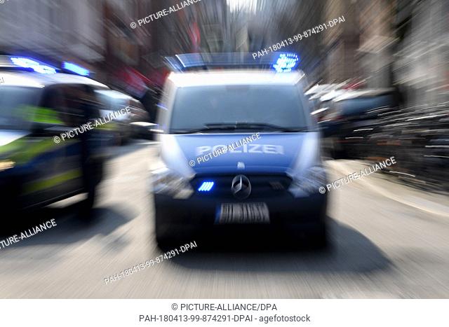 12 April 2018, Germany, Kiel: A German police vehicle with blue lights flashing (Photo taken using zoom effect). Photo: Carsten Rehder/dpa