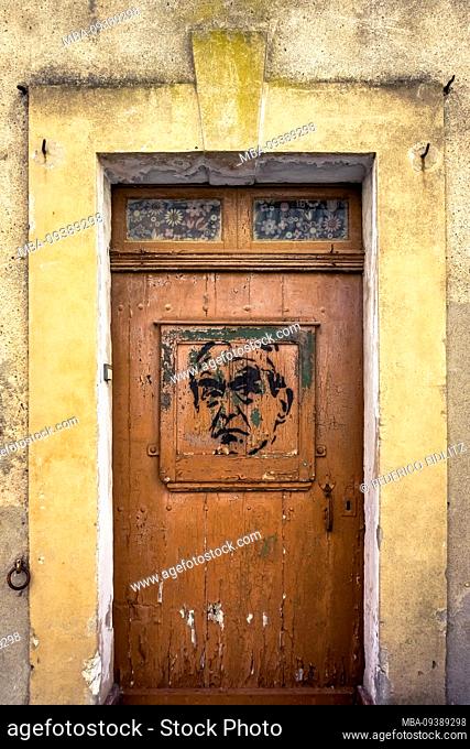 Wooden door with graffiti in Nissan lez Enserune