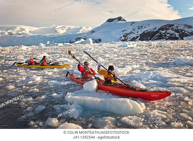 Kayakers paddle in brash ice among icebergs, Cierva Cove, Antarctic Peninsula