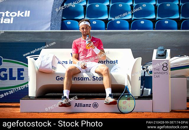 28 April 2021, Bavaria, Munich: Tennis: ATP Tour, Singles, Men, 2nd Round. Cuevas (Uruguay) - Ruud (Norway). Casper Ruud sits on the bench during a break