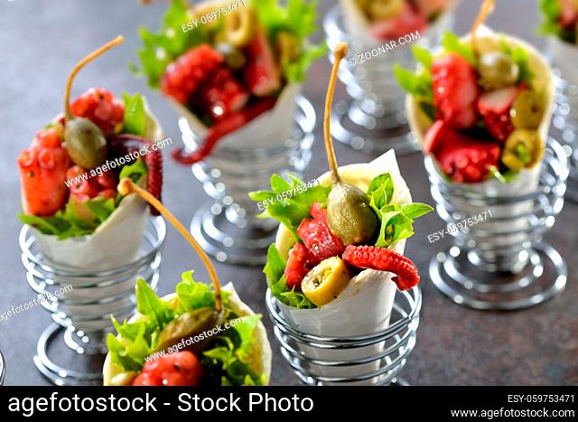 Partyfood: Mini-Wraps gefüllt mit Oktopussalat mit Oliven und Kapern - Mini tortillas stuffed with octopus salad with olives and capers, served in wire egg cups