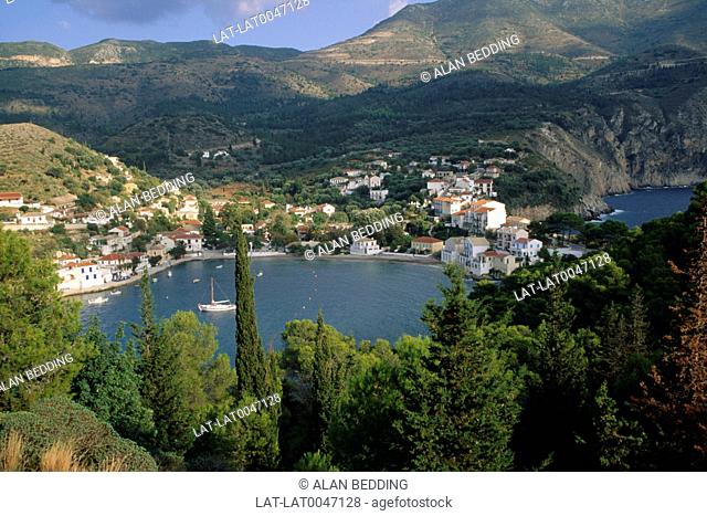 Cephallonia. Ionian islands. Sheltered bay. Village on hillside. Yacht. Boats moored. Trees