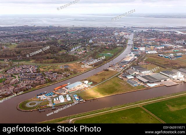 Aerial view Dutch residential area Delfzijl with channel Eemskanaal and industrial park near harbor