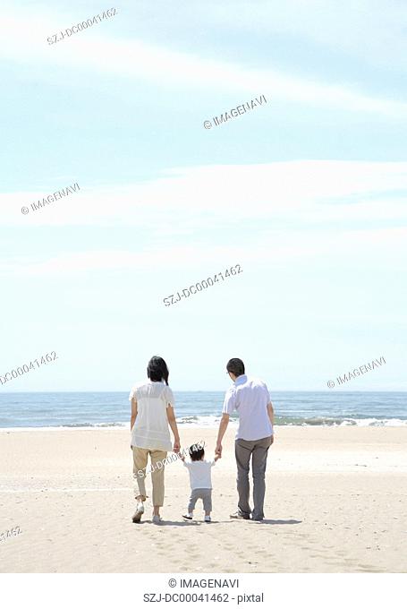 Parents and child walking on beach