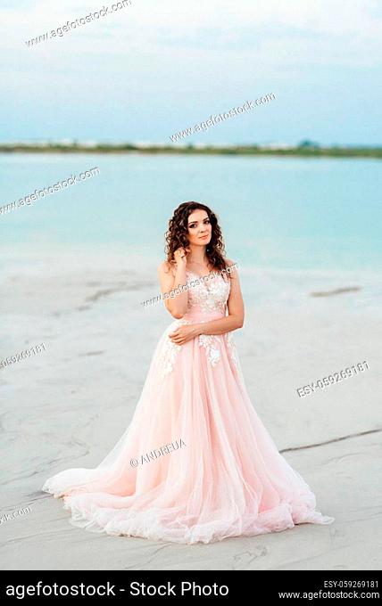 girl in a pink dress are walking along the white sand of the desert