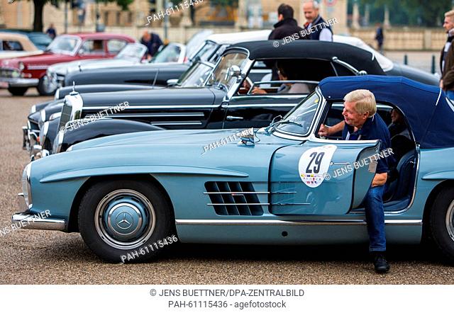 Hans-Dieter Kark starts the first stage of the 'Sunflower' rally 2015 with a Mercedes 300 SL car built in 1959, in front of the castle in Schwerin, Germany