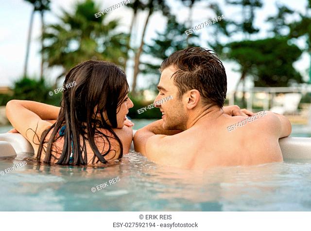 Young couple in a luxury hotel inside a jacuzzi in a rainy day