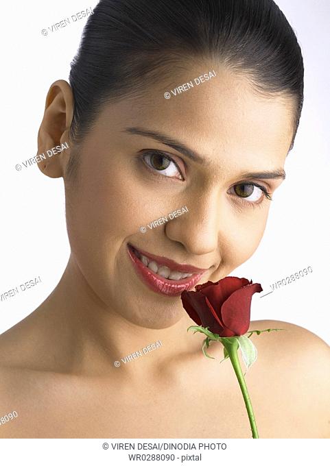South Asian Indian woman smiling holding and smelling red rose MR 702