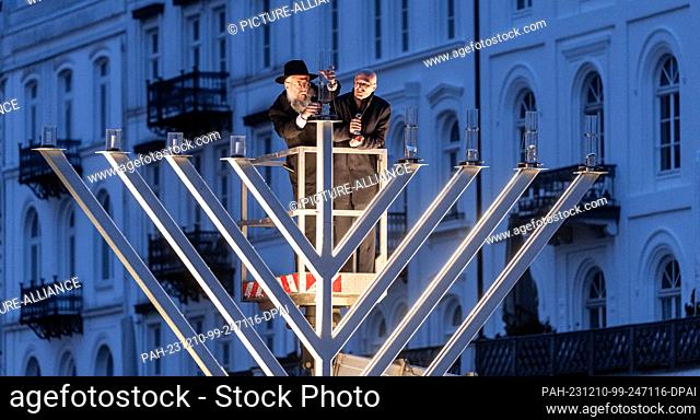 10 December 2023, Hamburg: State Rabbi Shlomo Bistritzky (l) and Peter Tschentscher (SPD), Mayor of Hamburg, light the approximately three-meter-high Hanukkah...
