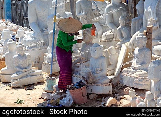 Frau beim Polieren einer Buddha Statur