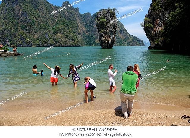 06 March 2019, Thailand, Khao Phing Kan: Tourists photograph themselves at the beach of the island Khao Phing Kan in front of the striking rock Khao Ta-Pu