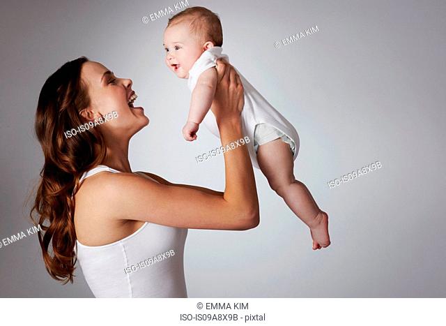 Mother lifting baby daughter