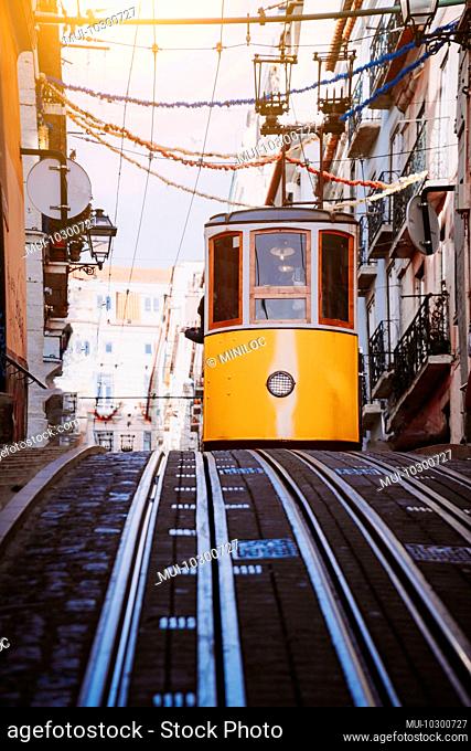 Lisbon's Gloria yellow funicular drives down the street. Lisbon. Portugal, Europe, West side of the Avenida da Liberdade connects downtown with Bairro Alto