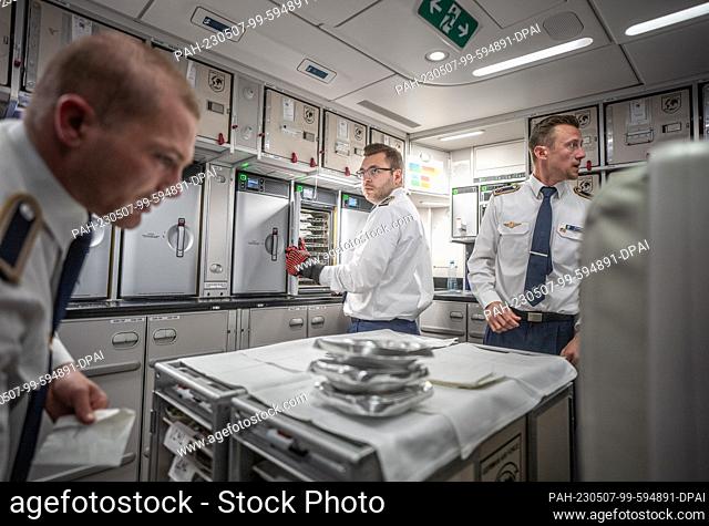 04 May 2023, Brandenburg, Schönefeld: Flight attendants prepare lunch in the kitchen on board the Airbus A350-900 ""Konrad-Adenauer"" of the BMVg's Special Air...