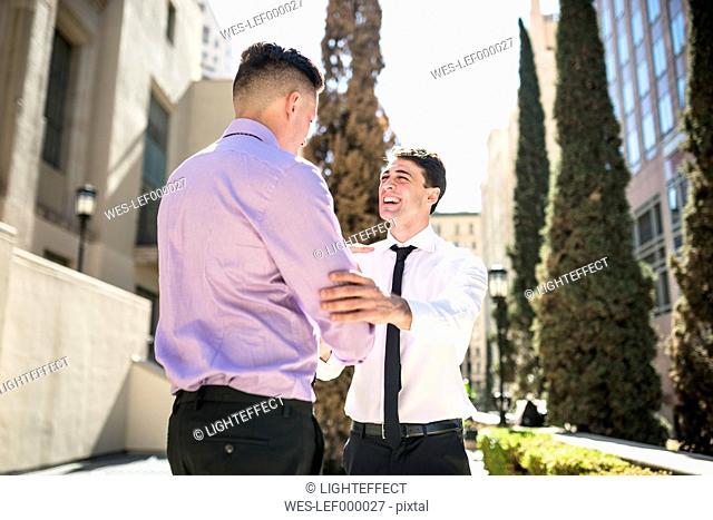 Two businessmen shaking hands outdoors
