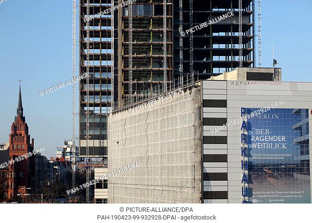 15 April 2019, Berlin: View of the dismantled outer façade and the gutted floors of the Steglitzer Kreisel while a huge poster on the façade with the slogan...