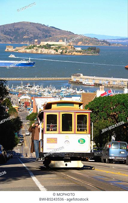 characteristical view of the city down a steep road with a streetcar in the foreground, USA, California, San Francisco
