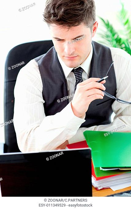 Worried male doctor looking at his laptop