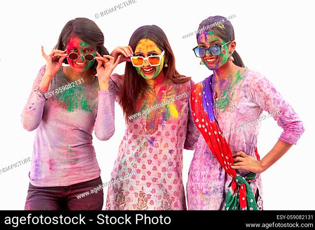 A GROUP OF YOUNG WOMEN HAPPILY POSING IN FRONT OF CAMERA AFTER CELEBRATING HOLI