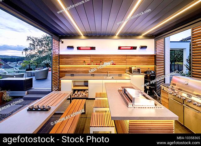 Modern outdoor kitchen in wood look with a warm lighting concept