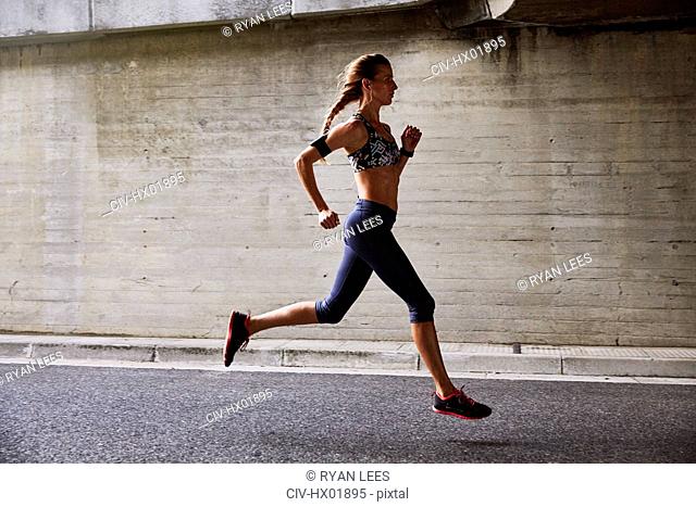 Female runner running on urban street