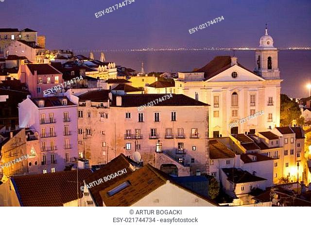 Old city of Lisbon at night in Portugal, Santo Estevao Church on the right