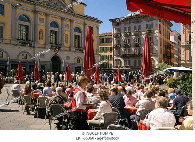 People sitting in a pavement cafea Piazza della Riforma, Lugano, Lake Lugano, Ticino, Switzerland