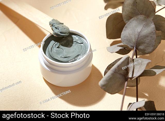 cosmetic clay mask in jar with wooden spatula