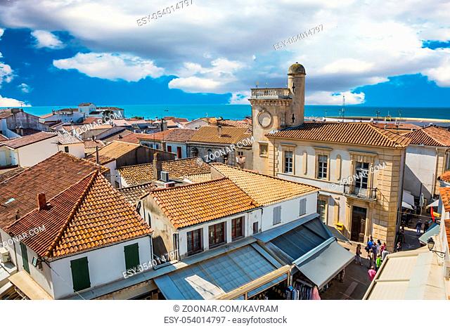 Orange and yellow tiled roofs of Provencal city Saintes-Maries-de-la-Mer. Mediterranean Sea. The concept of ethnographic tourism