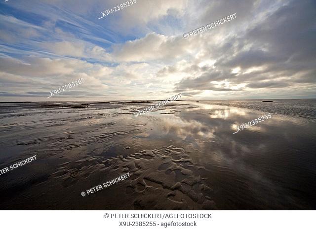 dark clouds reflected in the shallow water of the north sea, national park Wadden Sea World Heritage, Westerhever, district of North Frisia, Schleswig-Holstein