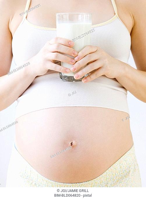 Pregnant Asian woman holding glass of milk