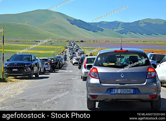 Cars of tourists invade the streets of the lentils bloom plain , Castelluccio di Norcia (Perugia) ITALY-07-07-2020